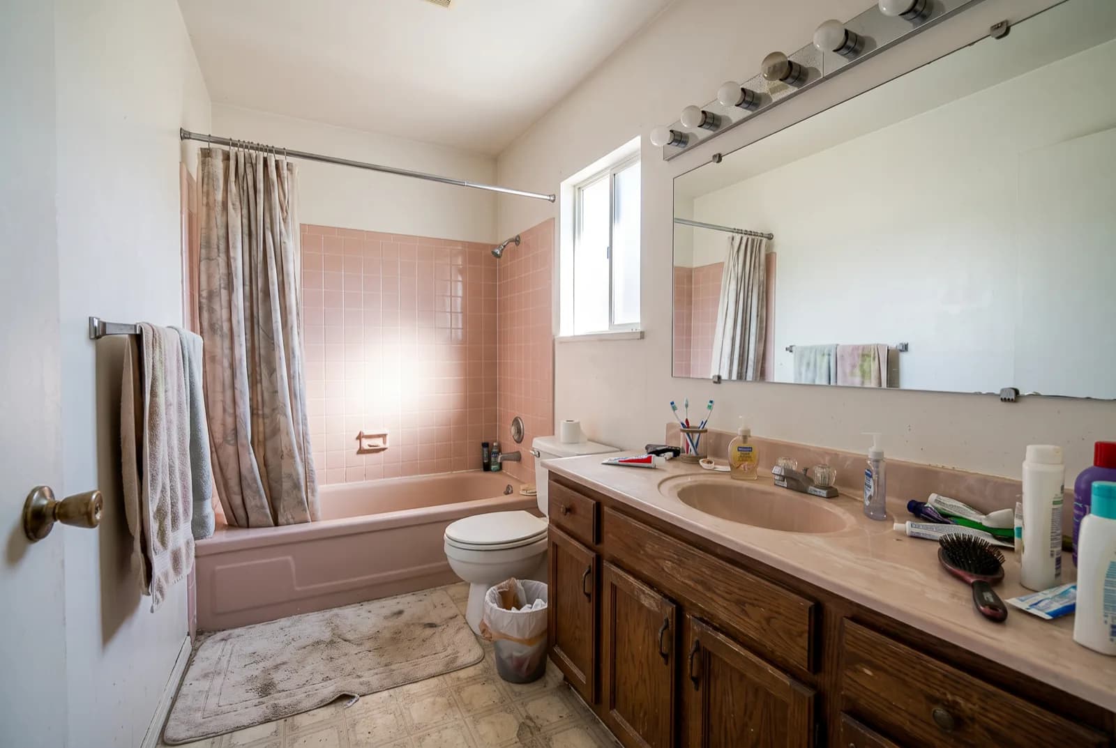 AI-generated sample redesign: Same bathroom redesigned in minimalist style: large-format stone tile, floating vanity and glass shower, before